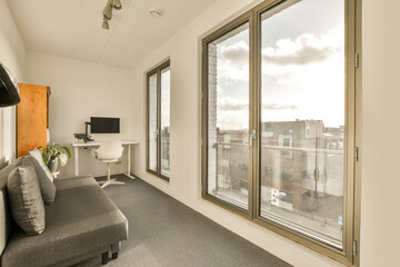 a living room with a couch and large window looking out onto the cityscapea is in the background