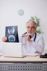 Old male doctor radiologist working in the clinic