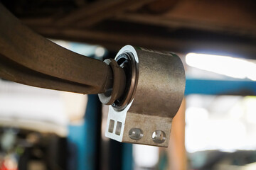 New car suspension bushings in parts replacement and car lift in the garage.Car suspension maintenance concept