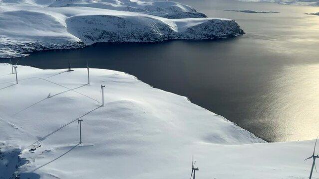 Havoysund Wind park on a sunny day, Aerial view from a helicopter, during winter in Northern Scandinavia