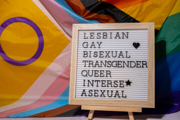 LGBTQIA description frame on Rainbow LGBTQIA flag made from silk material. LESBIAN, GAY, BISEXUAL,...