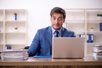 Young male employee and too much work in the office