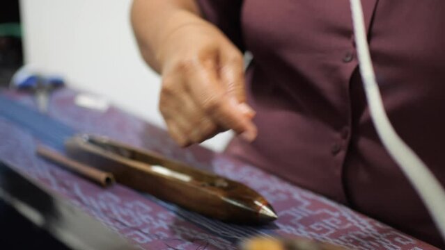 Selective focus traditional weaver is preparing yarn. Preparing the loom before starting to make woven ikat