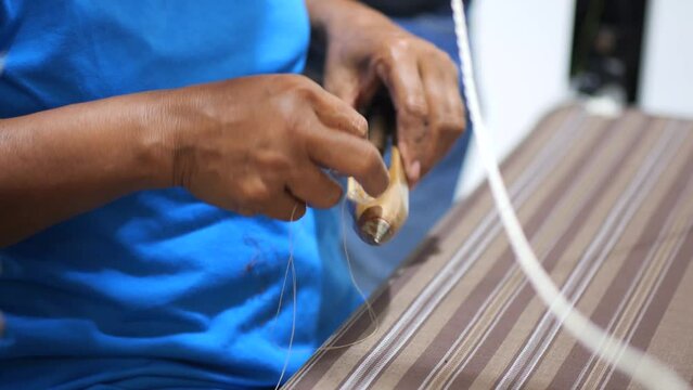 Selective focus traditional weaver is preparing yarn. Preparing the loom before starting to make woven ikat