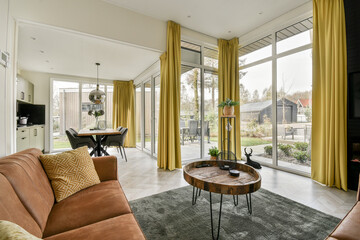 a living room with two couches and a coffee table in front of the window looking out to the backyard
