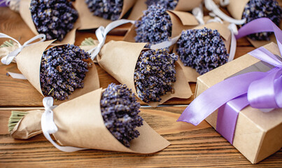 Fragrant cute lavender bouquets wrapped in craft paper and ribbon on a wooden table