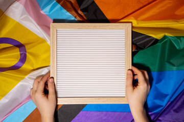 Empty blank frame on Rainbow LGBTQIA flag made from silk material with copy space for your text....