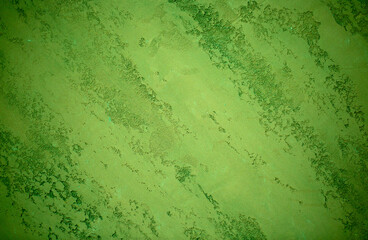 Green background from decorative plaster with abstract spots. Unusual green wall texture with beautiful patterns, creative surface background. Front covering for facing of buildings.