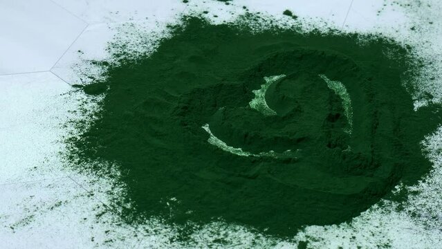 Female hand draw heart on Blue-green algae Chlorella and spirulina powder. Super powder. Natural supplement of algae. Detox superfood drink cocktail. Food supplement source of protein and beta
