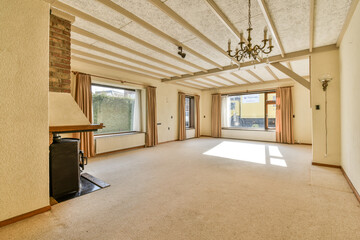 an empty living room with wood beams on the ceiling and large windows overlooking out onto the street in the distance