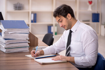 Young male employee and too much work in the office