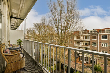 Fototapeta premium a balcony with a chair and tree in the foreground, taken from an apartment building's roof terrace