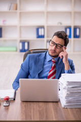 Young male employee unhappy with excessive work in the office