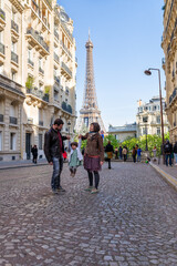 Couple with their little daughter enjoying a walk around Eiffel Tower area in Paris.