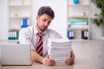 Young male employee and too much work in the office