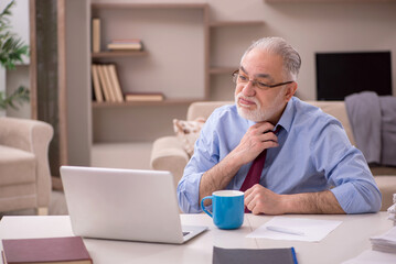 Old male employee working from home during pandemic