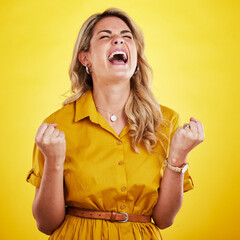 Woman, fist celebration and shout in studio for winning, goals or success with happiness by yellow...