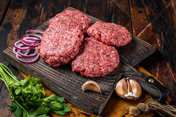 Fresh Raw burger patty, mince beef Meat, uncooked meat cutlets. Wooden background. Top view