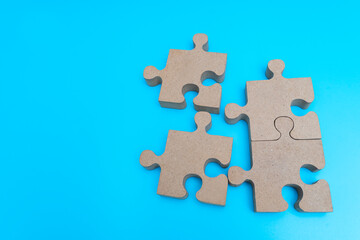 Fototapeta premium Top view. wooden Jigsaw Puzzle parts on blue background. four puzzles form a rectangle