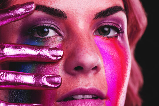 Woman, beauty portrait and metallic color paint or cosmetics on skin, hand and face in studio. Female model person on a black background for art deco, fantasy and creative makeup with a neon light