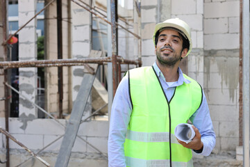 Caucasian technician civil engineer man or specialist inspector standing and planing real estate project work with blueprint while checking at Industrial building site. Construction concept