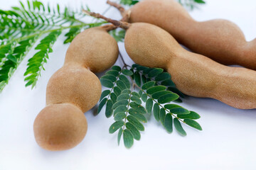 fresh Delicious ripe tamarinds, tamarind with brown pulp with green leaf.