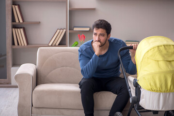 Young male contractor looking after baby at home