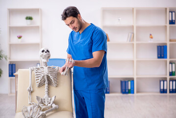 Obraz premium Young male doctor and skeleton patient at the hospital