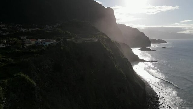 Peaceful Sao Jorge town on coastal cliff on Madeira island, Portugal, aerial