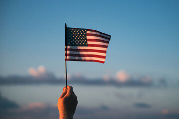 Man holding a waving american USA flag. - Powered by Adobe