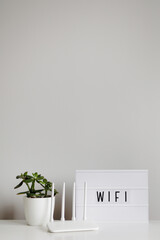 white router and plant on table with copy space