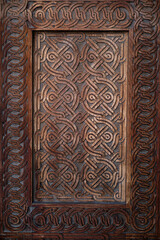 Fototapeta na wymiar Vertical image of a fragment of a wooden front door in an old building.