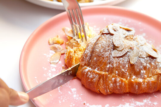 Brioche almond croissant eating at a fancy cafe.