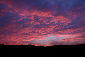 Bright pink sunset clouds over horizon
