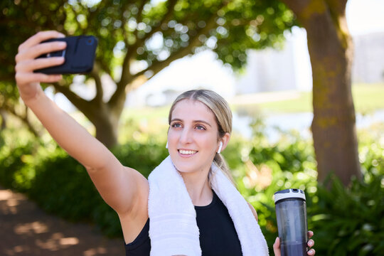 Park, happy woman or fitness influencer taking a selfie at training, running or workout in a park. Smile, runner or healthy girl athlete in headphones talking pictures or photo to relax on a break