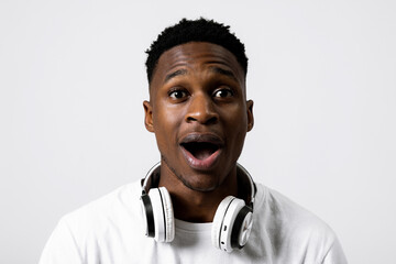 Emotional handsome portrait of delighted susprised african american black guy with headphones over...
