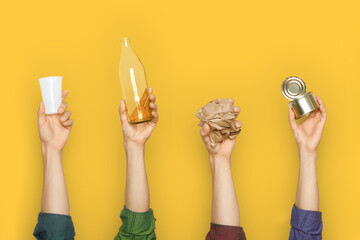 Hands keep garbage on a yellow background