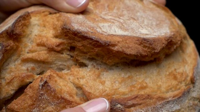 static macro slow motion shot of woman's fingers breaking the white bread
