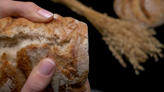 static macro slow motion shot of woman's fingers breaking the white bread