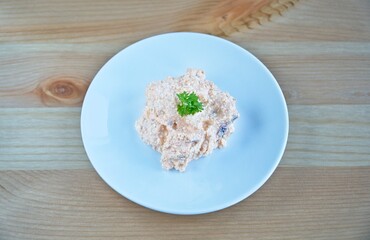 Close up of a homemade hungarian liptauer (in hungarian: Körözött), cheese spread on wooden table in a white plate.