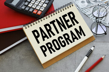 partner program serving wooden background. with text on notepad