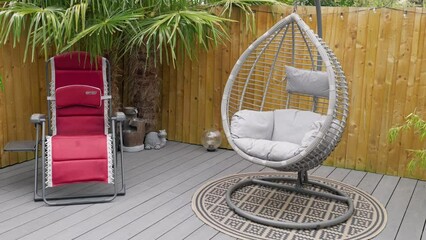 Minimalistic UK summer garden showing swing chair decking and sun lounger. - Powered by Adobe