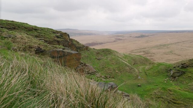 Pule Hill near Marsden in Yorkshire. Aerial drone view of rugged Pennine hill tops, on a foggy morning, golden hills and rocky moorlands