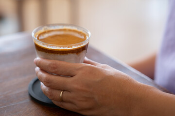 A Glass of coffee with milk called Dirty Coffee one of the famous coffee menu on woman hand