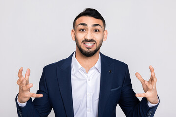 Happy cheerful man in buuisness suit with white shirt looking at camera surprised shocked telling about low prices sales in the shop guy in good mood.