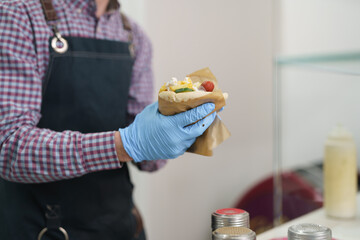 The cook preparing gyros sandwich for take away. Chef cooking traditional Greek wrap with pita bread and souvlaki meat