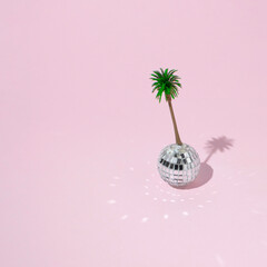 Creative layout with disco ball decoration and  palm trees on pink background. Summer party concept. Trendy background.