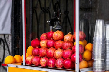 Oranges and pomegranates for juice on the counter of the street market.