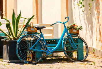 Fototapeta na wymiar Cute blue bike with baskets with flowers in old town Tbilisi, Georgia.