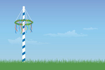 Fototapeta na wymiar maypole with colorful ribbons on green meadow